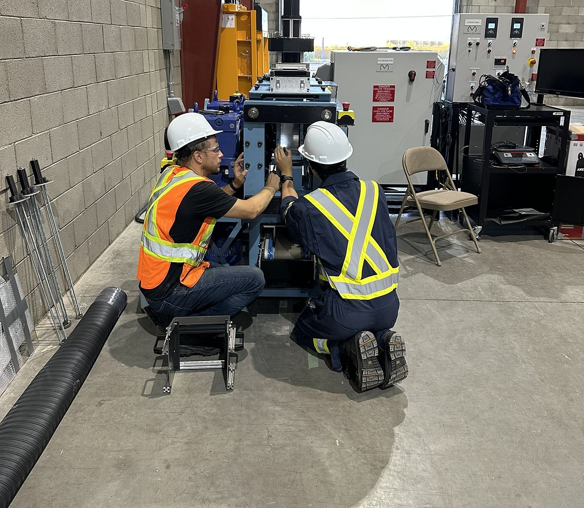 Two engineers in hard hats setting up a Minpraxis Tester